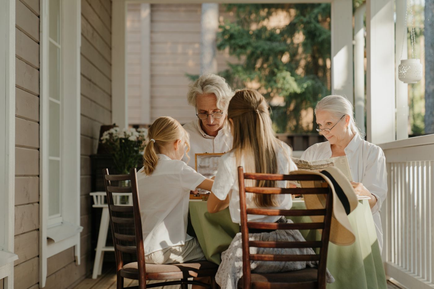 Three generations around a summer table on a white porch